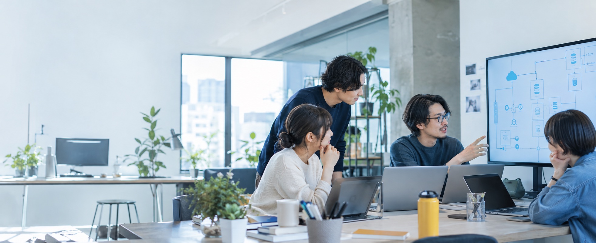システム構成を見ながら話し合うエンジニアチーム
